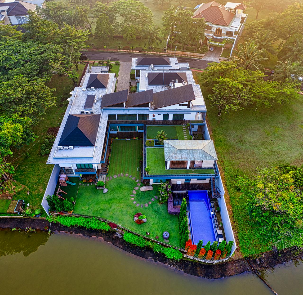 A stunning aerial view of a luxury riverside mansion in Tangerang, Indonesia.