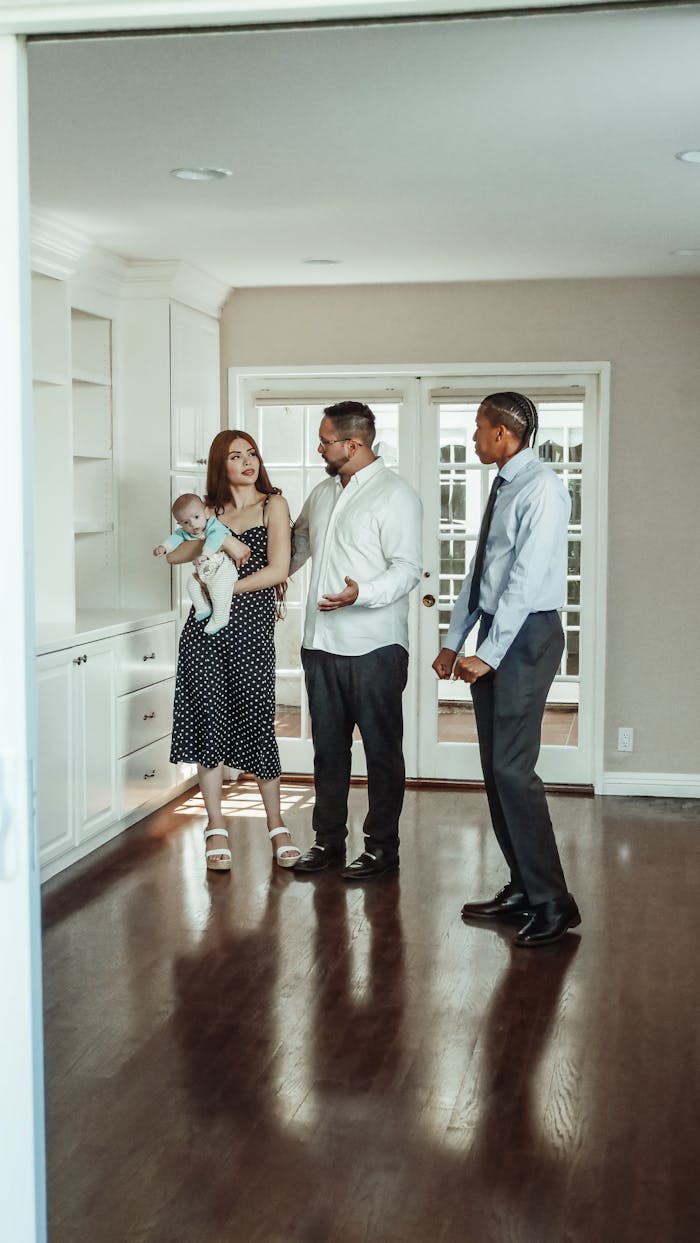 Services A couple with a baby and a realtor discuss details during a home tour.
