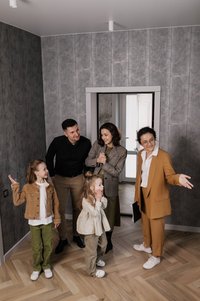 Home A family of four joyfully exploring their new home with a real estate agent.